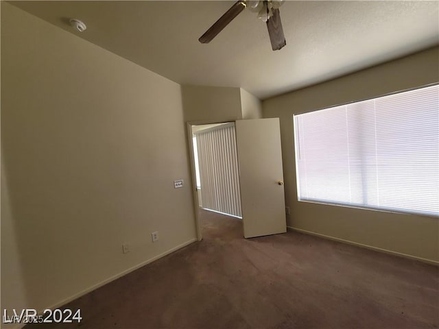 empty room featuring baseboards, a ceiling fan, and carpet