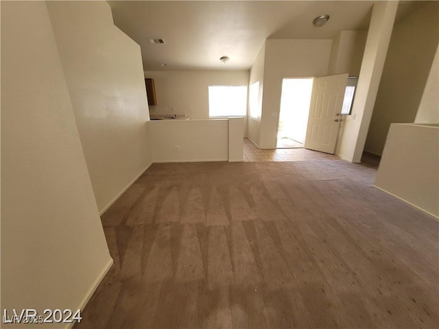 empty room featuring baseboards, wood finished floors, and visible vents