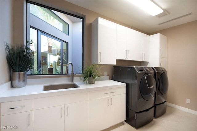 661 Dragon Peak Dr, Henderson, NV 89012 - laundry area with a sink, cabinet space, independent washer and dryer, light tile patterned floors, and baseboards
