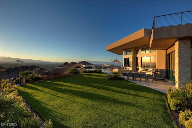 661 Dragon Peak Dr, Henderson, NV 89012 - yard at dusk with an outdoor hangout area and a patio