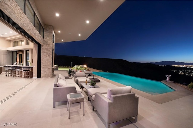 661 Dragon Peak Dr, Henderson, NV 89012 - pool at night with indoor bar and a mountain view