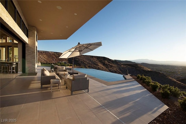 661 Dragon Peak Dr, Henderson, NV 89012 - view of patio / terrace featuring an infinity pool and a mountain view