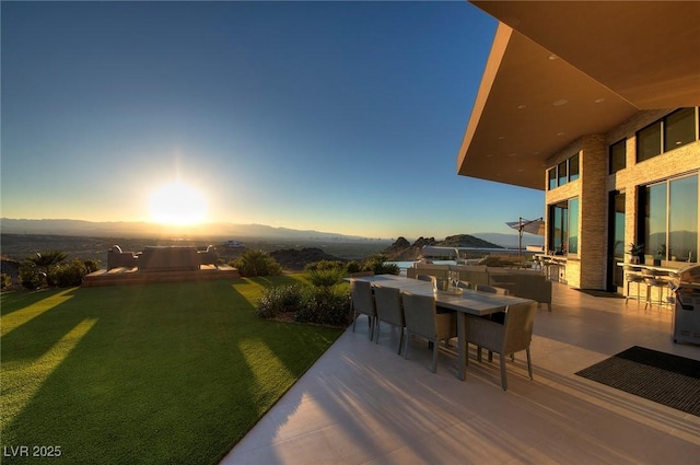661 Dragon Peak Dr, Henderson, NV 89012 - yard at dusk featuring a mountain view, a patio, and outdoor dining space