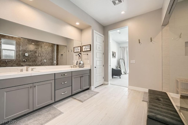 full bath with a sink, double vanity, recessed lighting, wood finished floors, and visible vents