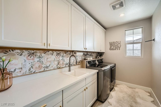 laundry room featuring cabinet space, a sink, separate washer and dryer, baseboards, and visible vents