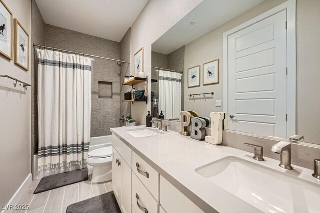 full bathroom with double vanity, a sink, shower / tub combo, and toilet