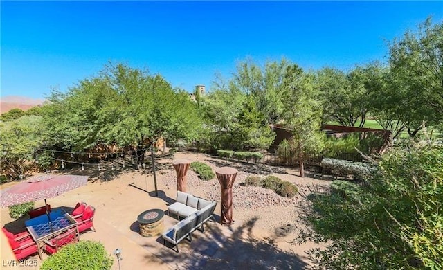 view of property's community featuring an outdoor living space with a fire pit and a patio