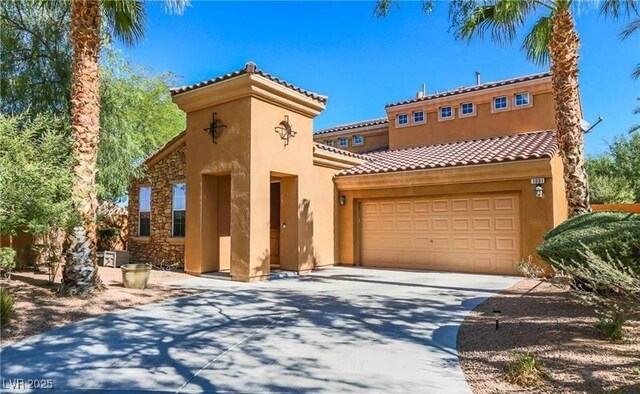 mediterranean / spanish-style house featuring stucco siding, a tile roof, a garage, and concrete driveway