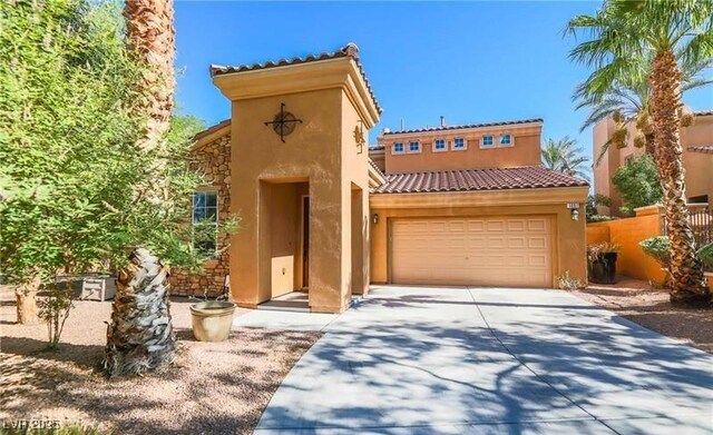 mediterranean / spanish house with stucco siding, an attached garage, driveway, and a tiled roof