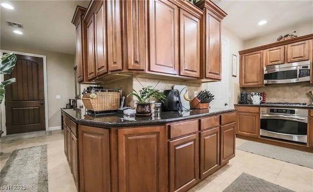 kitchen featuring recessed lighting, brown cabinets, stainless steel appliances, visible vents, and decorative backsplash