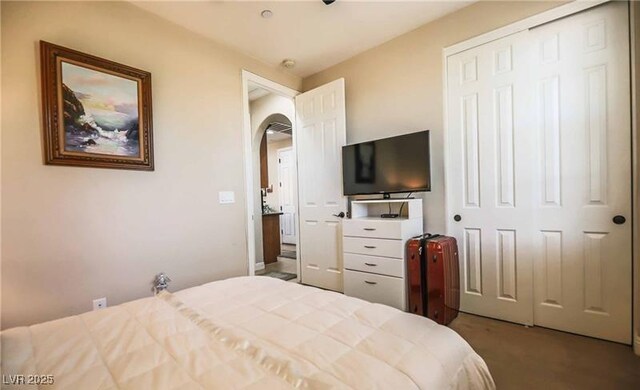 bedroom featuring arched walkways, carpet, and a closet
