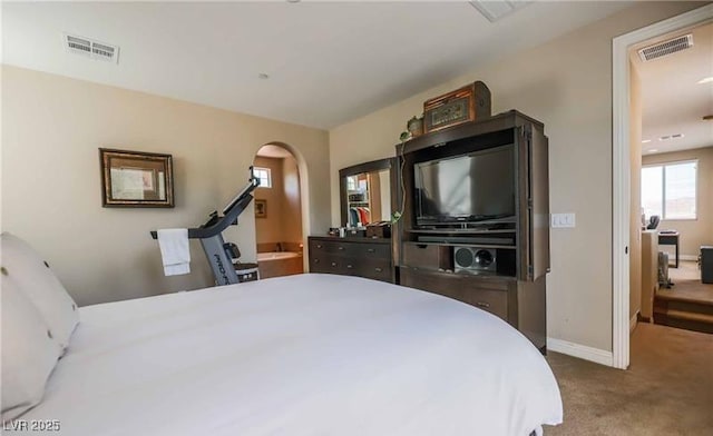bedroom with arched walkways, carpet, visible vents, and baseboards
