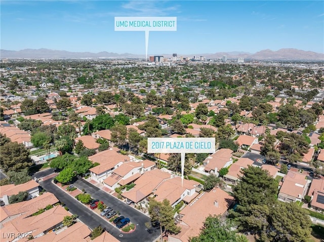 aerial view of property's location featuring a mountain backdrop and nearby suburban area
