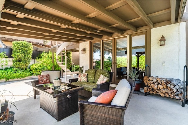 view of patio featuring stairway, an outdoor hangout area, and fence