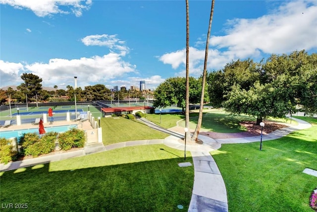 view of community featuring a tennis court and a lawn