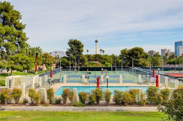 view of pool featuring fence and a tennis court