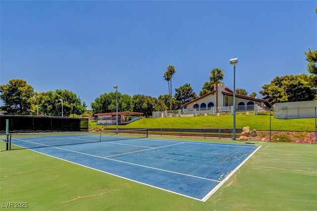 view of tennis court featuring fence