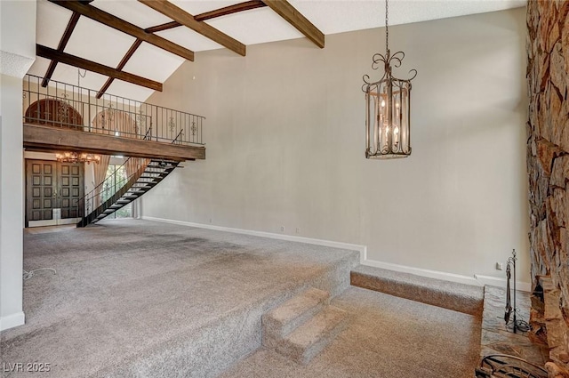 unfurnished living room featuring a chandelier, carpet, high vaulted ceiling, stairway, and beam ceiling