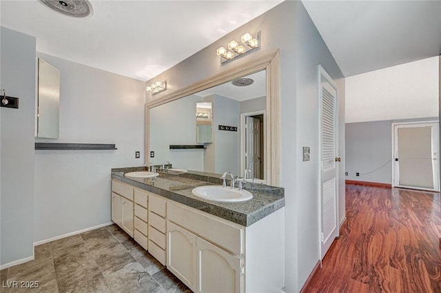 full bathroom with baseboards and double vanity