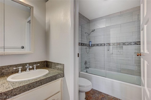 bathroom with toilet, shower / bath combination with glass door, and vanity