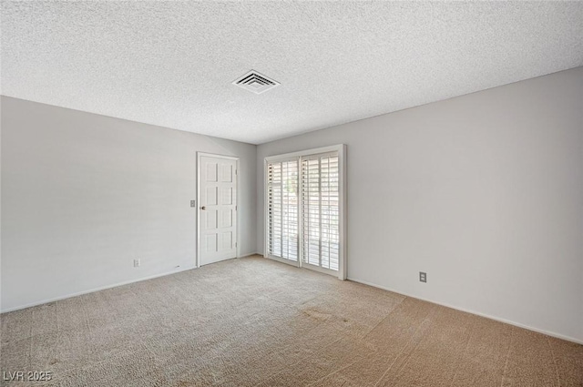 carpeted empty room with a textured ceiling