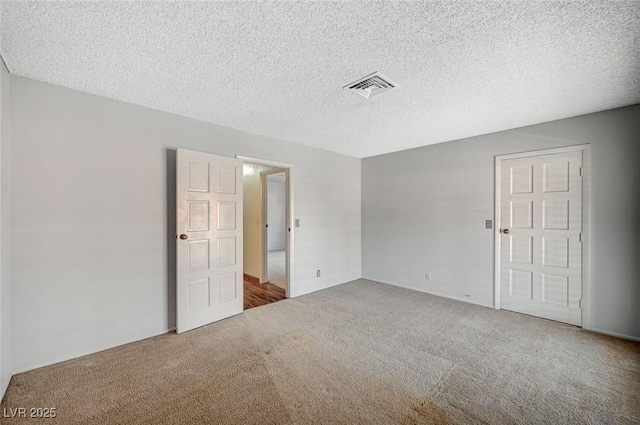 unfurnished bedroom featuring carpet floors, a textured ceiling, and baseboards