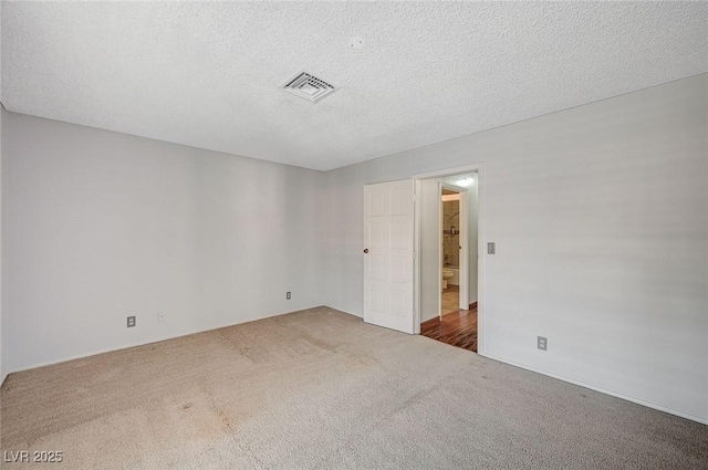spare room with carpet floors and a textured ceiling