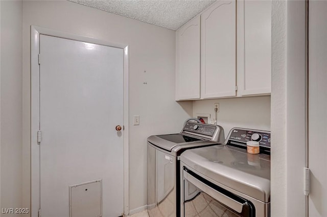 laundry area featuring cabinet space, washing machine and clothes dryer, and a textured ceiling