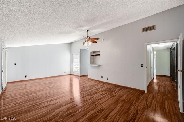 unfurnished living room with a ceiling fan, lofted ceiling, wood finished floors, a textured ceiling, and baseboards