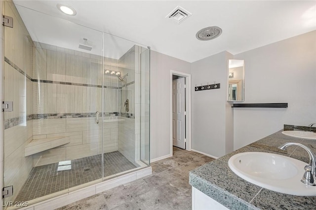 full bath featuring a stall shower, baseboards, and double vanity
