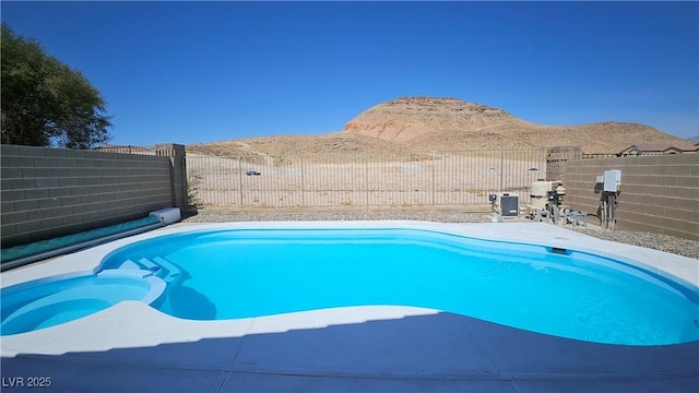 83 Rock Run St, Las Vegas, NV 89148 - view of pool with a pool with connected hot tub, a fenced backyard, and a mountain view