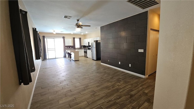 83 Rock Run St, Las Vegas, NV 89148 - kitchen with wood finished floors, open floor plan, ceiling fan, visible vents, and freestanding refrigerator