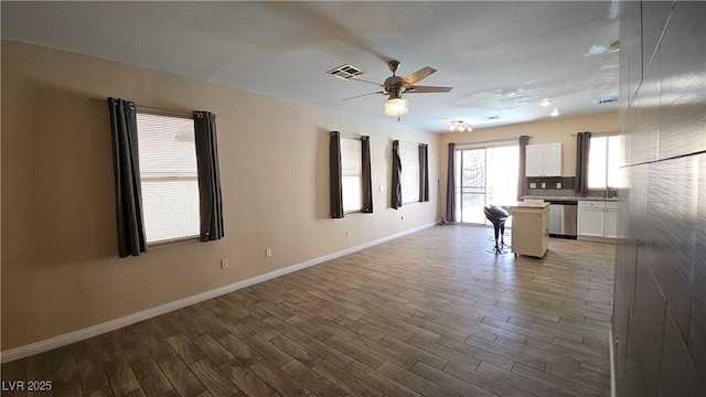 83 Rock Run St, Las Vegas, NV 89148 - unfurnished living room featuring baseboards, wood finished floors, visible vents, and ceiling fan