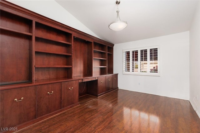 unfurnished office featuring dark wood-style flooring, built in desk, and lofted ceiling