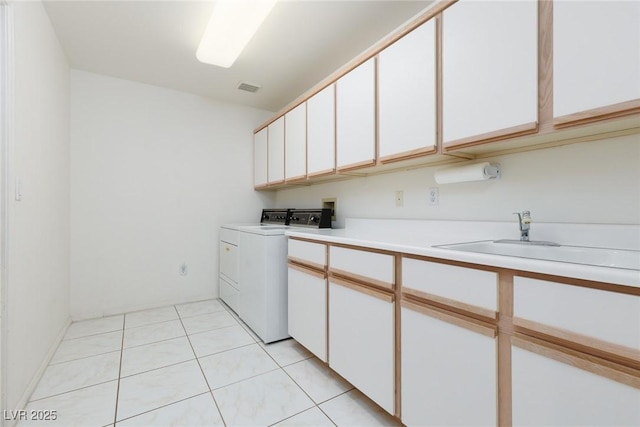 clothes washing area featuring visible vents, light tile patterned flooring, washing machine and clothes dryer, a sink, and cabinet space