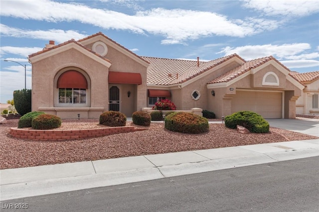 mediterranean / spanish-style home with an attached garage, stucco siding, driveway, and a tile roof
