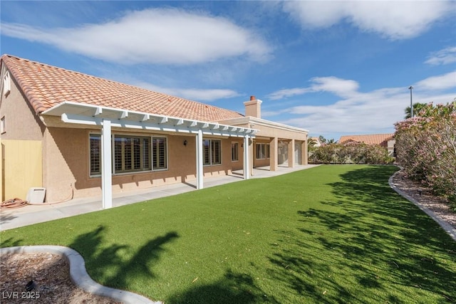 rear view of house with a lawn, a pergola, stucco siding, and a patio