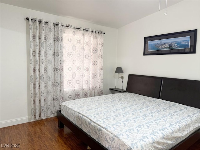 bedroom featuring baseboards and wood finished floors