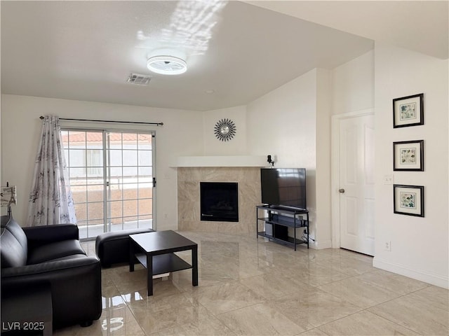 living area featuring a high end fireplace, baseboards, visible vents, and marble finish floor