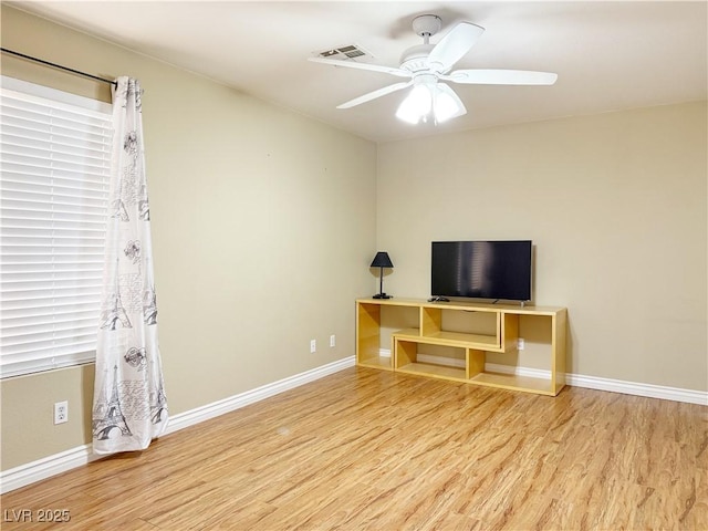 unfurnished living room with a ceiling fan, baseboards, visible vents, and wood finished floors