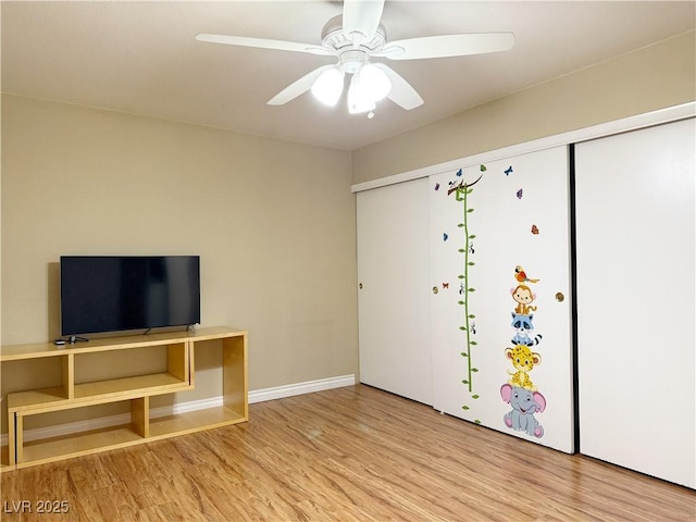 unfurnished living room featuring baseboards, a ceiling fan, and wood finished floors