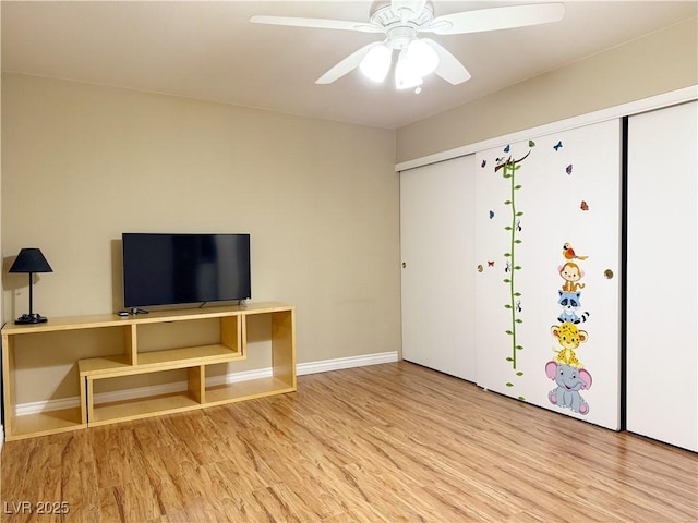 interior space with baseboards, ceiling fan, and wood finished floors
