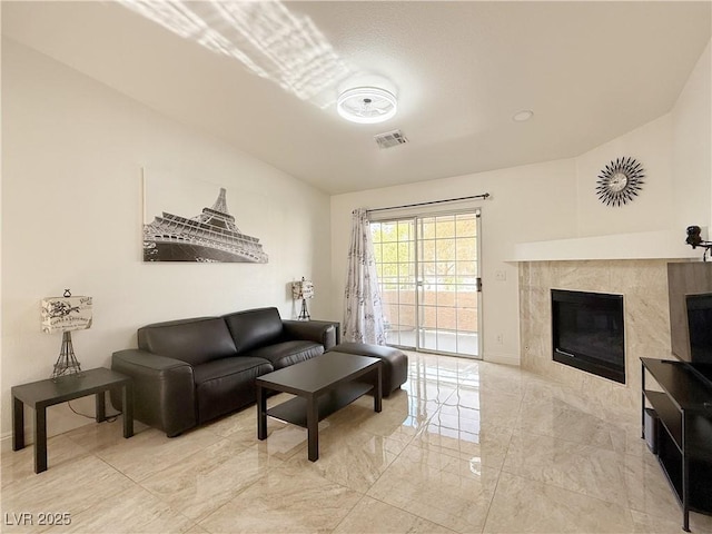 living area featuring visible vents, marble finish floor, baseboards, and a fireplace