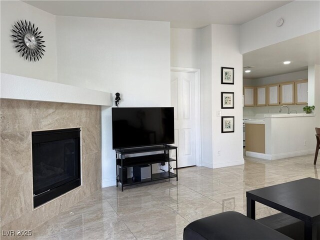 living room with recessed lighting, baseboards, a tiled fireplace, and marble finish floor