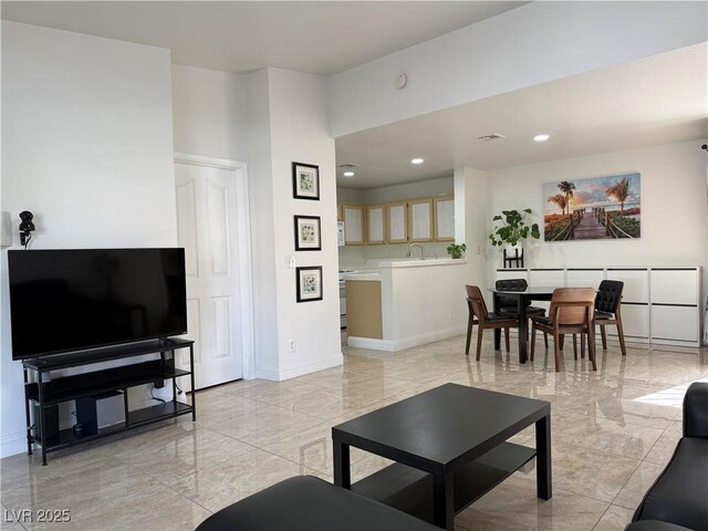 living room with recessed lighting, marble finish floor, and baseboards
