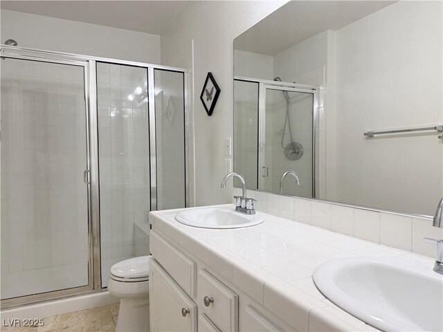 bathroom featuring toilet, a shower stall, and a sink