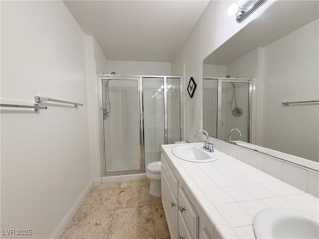 full bath with a sink, a shower stall, toilet, and double vanity