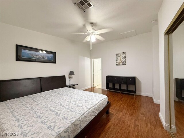 bedroom featuring visible vents, a ceiling fan, baseboards, and wood finished floors