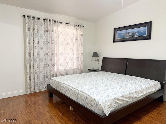 bedroom featuring baseboards and wood finished floors