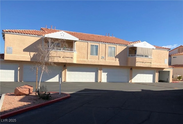 8452 Boseck Dr Unit 225, Las Vegas, NV 89145 - townhome / multi-family property featuring driveway, stucco siding, a garage, and a tile roof
